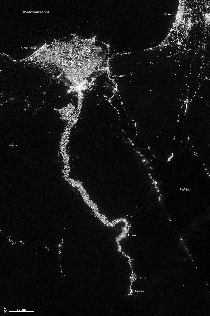 Night-time satellite view of city lights tracing the Nile river across dark desert terrain.